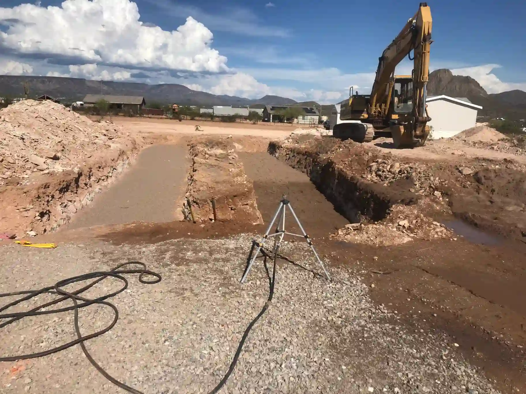 Septic installation Phoenix - Mitchell Excavating excavator cutting leach field trenches with a laser level on a North Phoenix lot